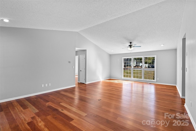 empty room featuring baseboards, wood finished floors, a ceiling fan, and vaulted ceiling