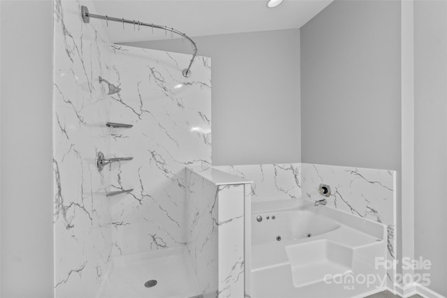 bathroom featuring a marble finish shower and a tub with jets