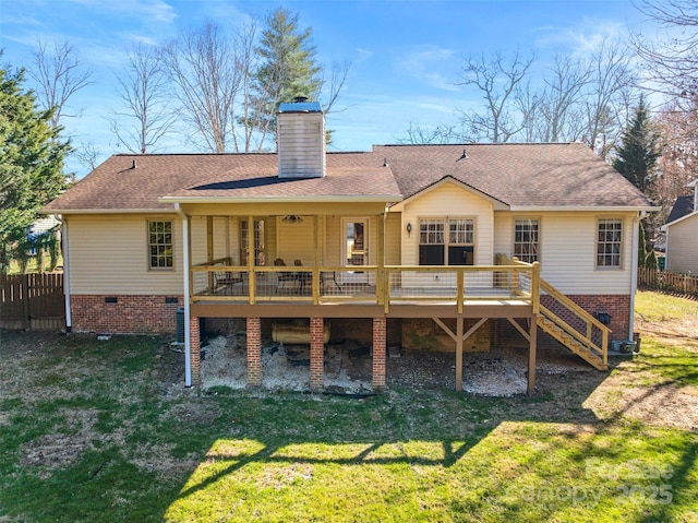 rear view of property featuring a wooden deck, a yard, and fence