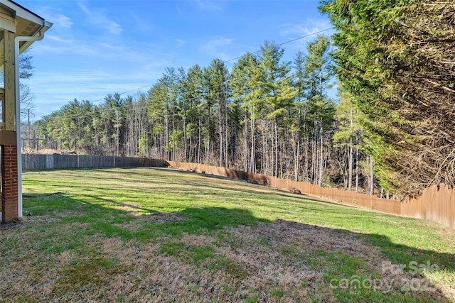 view of yard with a view of trees and fence