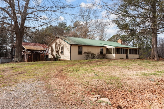 exterior space featuring a sunroom and a yard