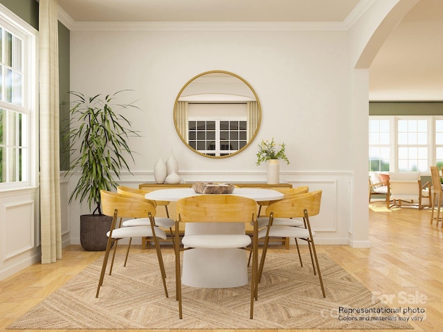 dining area with arched walkways, ornamental molding, and a decorative wall