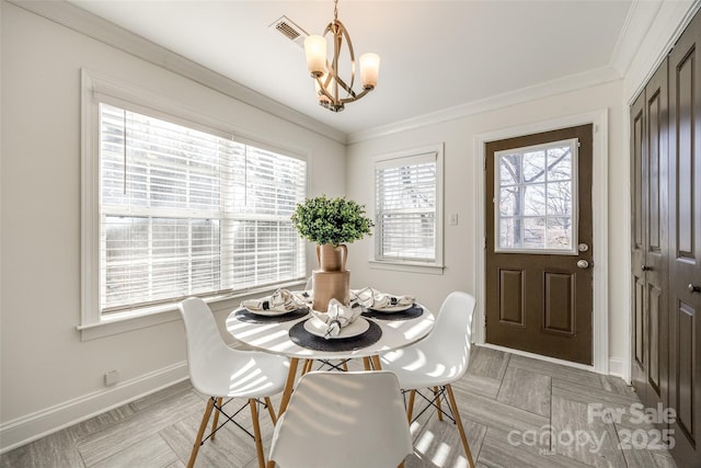 dining area featuring baseboards, visible vents, a chandelier, and crown molding