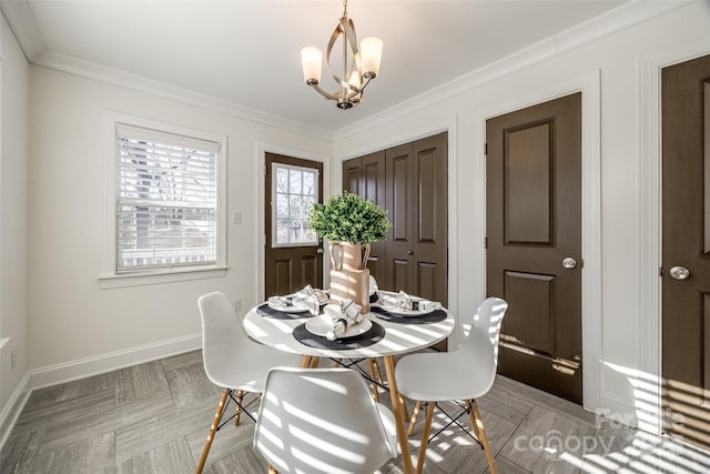 dining area featuring a chandelier, ornamental molding, and baseboards