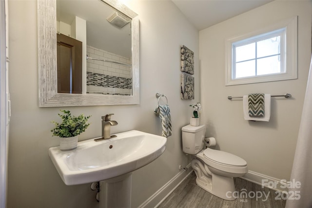 full bath with a sink, wood finished floors, toilet, and baseboards