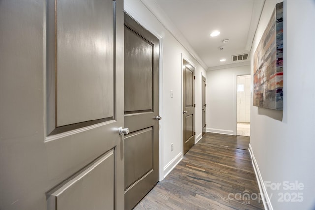 corridor featuring recessed lighting, dark wood-style flooring, visible vents, baseboards, and ornamental molding