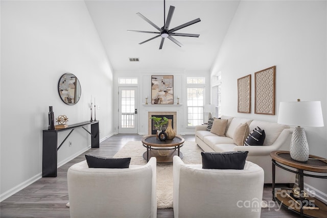 living room featuring wood-type flooring, high vaulted ceiling, ceiling fan, and a fireplace