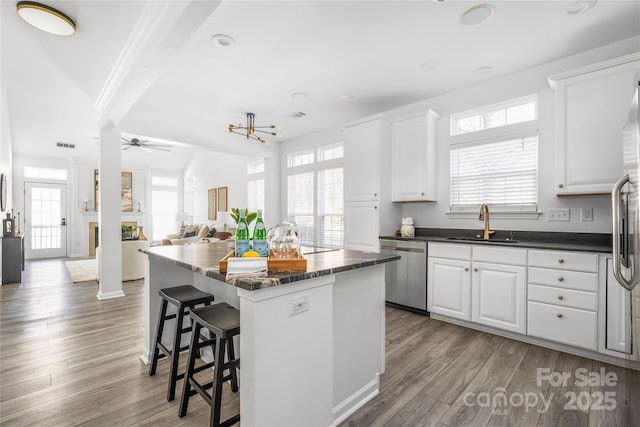 kitchen with sink, a center island, and white cabinets