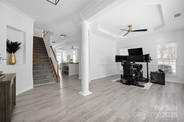 living room featuring crown molding, light hardwood / wood-style flooring, and ornate columns