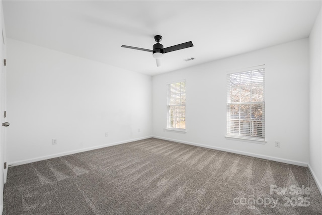 spare room with dark carpet and ceiling fan