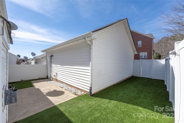 view of side of property featuring a yard and a patio