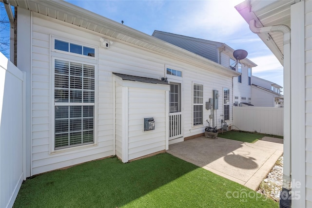 back of property featuring a lawn and a patio