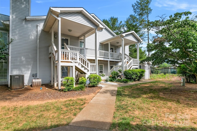 view of front of home featuring cooling unit, a porch, and a front lawn