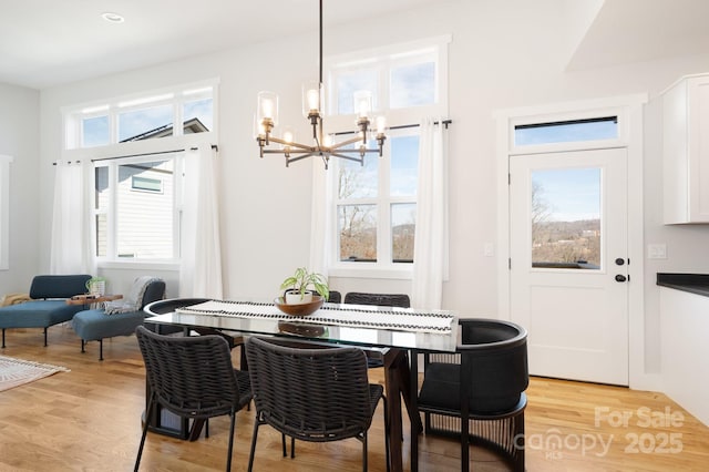 dining area featuring light wood-type flooring and a chandelier