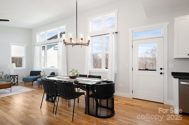 dining area with an inviting chandelier and light hardwood / wood-style floors