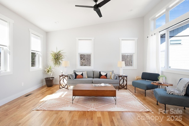 living room featuring ceiling fan, plenty of natural light, light hardwood / wood-style floors, and lofted ceiling