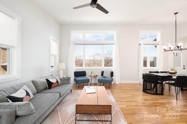 living room with hardwood / wood-style flooring and ceiling fan with notable chandelier