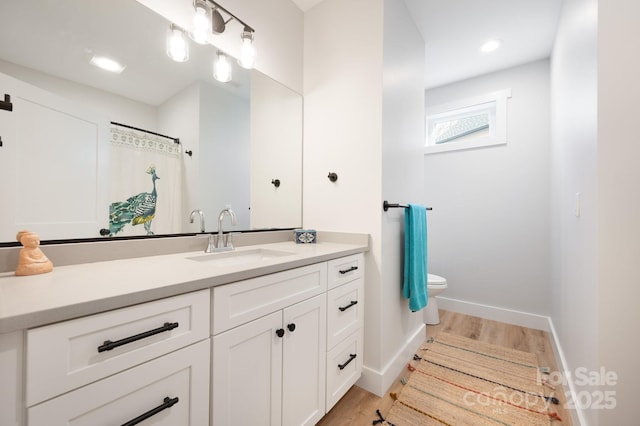 bathroom featuring toilet, hardwood / wood-style flooring, and vanity