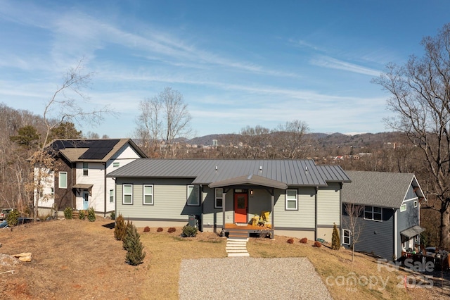 view of front facade with a front lawn, covered porch, and a mountain view