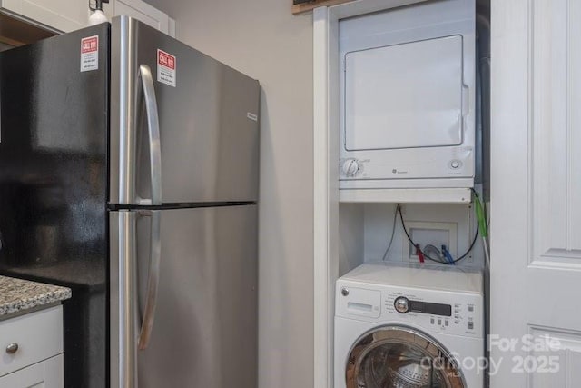 laundry area featuring stacked washer / drying machine