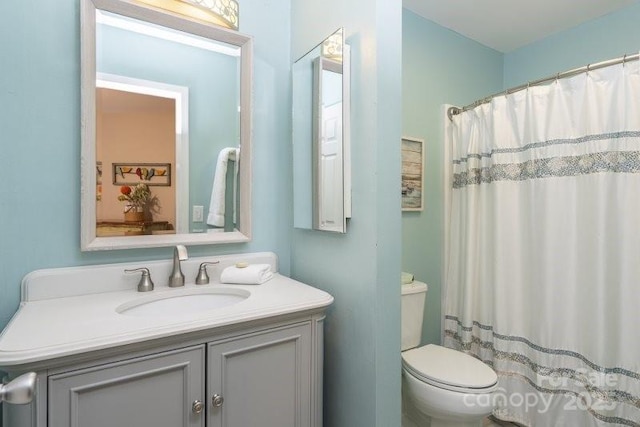 bathroom featuring a shower with curtain, vanity, and toilet