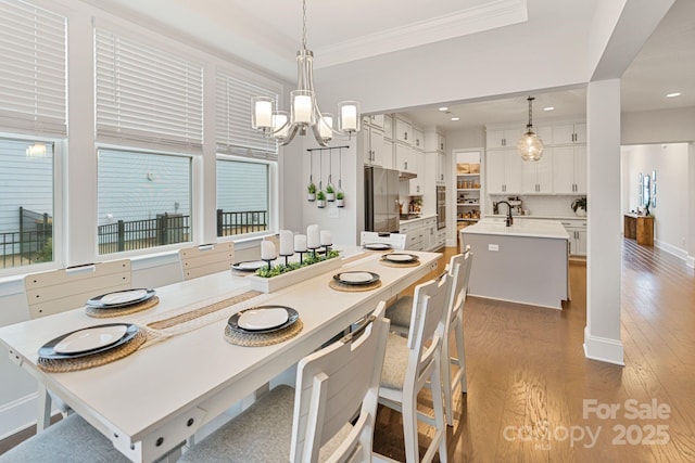 dining space featuring ornamental molding, hardwood / wood-style floors, and a notable chandelier