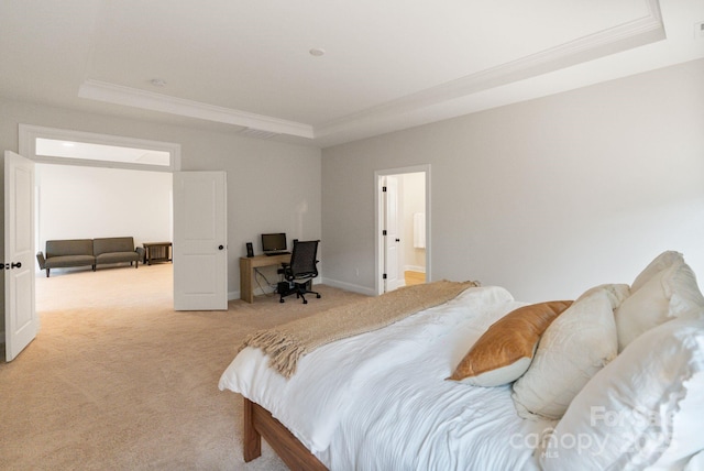 bedroom featuring crown molding, light colored carpet, and a tray ceiling