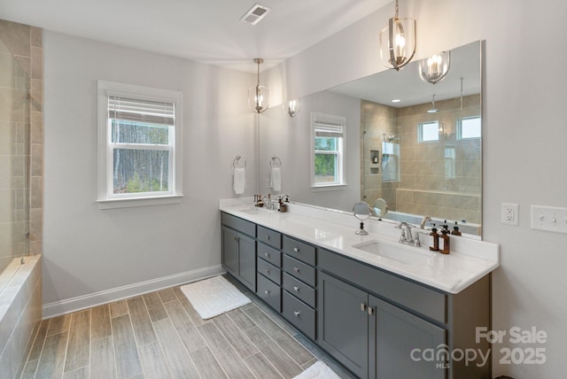 bathroom with a tile shower, vanity, and wood-type flooring