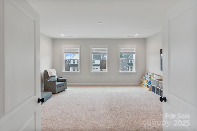 living area with plenty of natural light and carpet