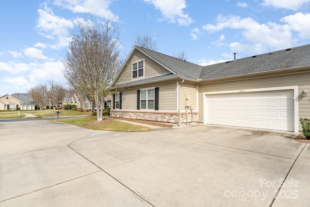 view of front of house with driveway, a garage, a shingled roof, stone siding, and a residential view