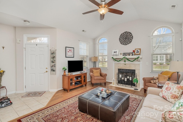 living area with vaulted ceiling, ceiling fan, light tile patterned flooring, and visible vents