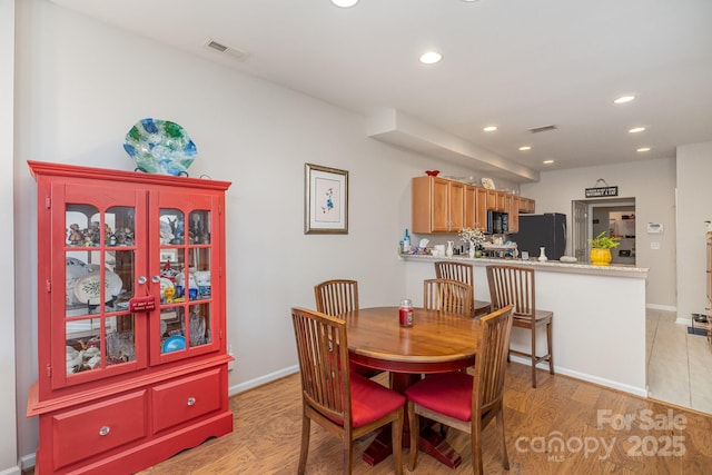 dining room with recessed lighting, visible vents, light wood-style flooring, and baseboards