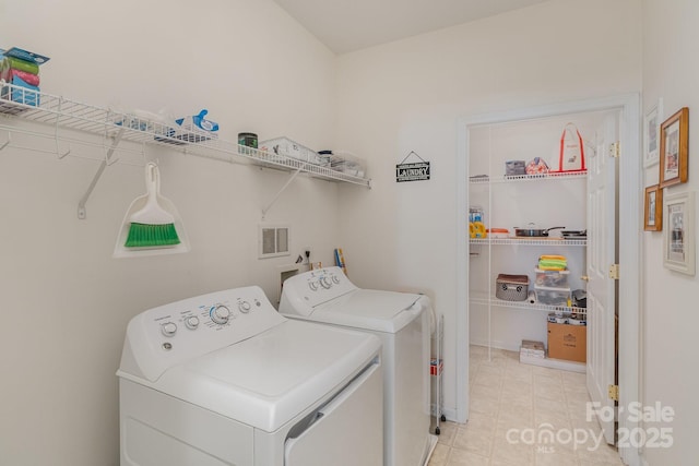 clothes washing area with laundry area, washer and clothes dryer, and visible vents