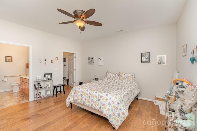 bedroom with light wood-type flooring, ceiling fan, baseboards, and connected bathroom