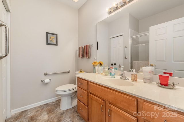 bathroom with toilet, a stall shower, baseboards, and vanity