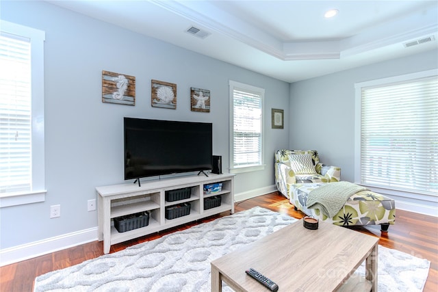 interior space with hardwood / wood-style floors and a tray ceiling