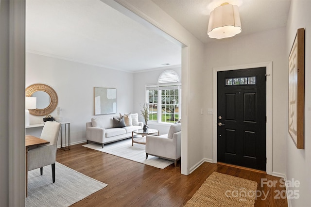 foyer with hardwood / wood-style flooring and ornamental molding