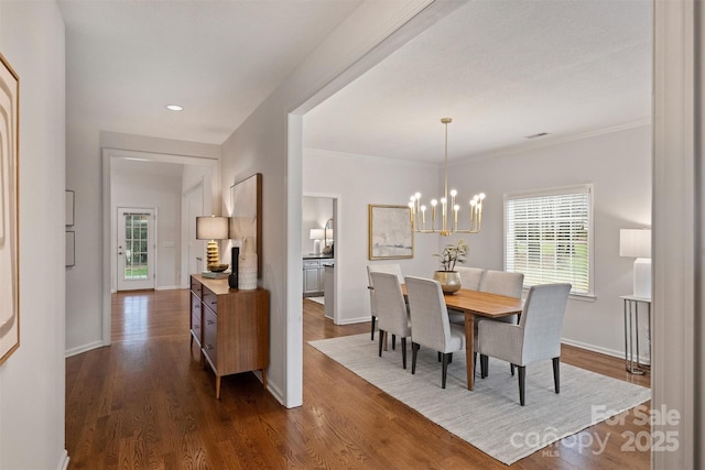 dining room with ornamental molding, dark hardwood / wood-style floors, and a notable chandelier