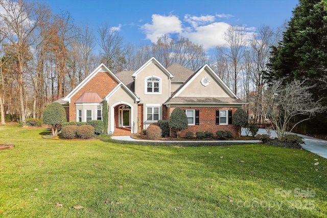 traditional-style house featuring stucco siding, a front lawn, and brick siding