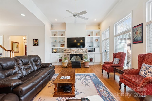 living area with ornamental molding, recessed lighting, a fireplace, and light wood finished floors