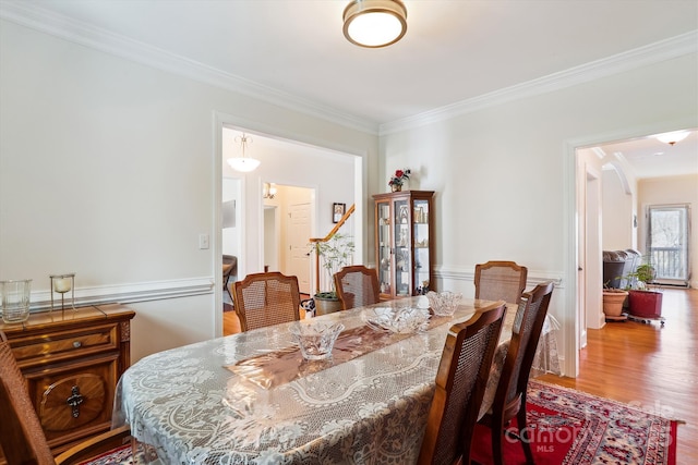 dining space with crown molding and wood finished floors