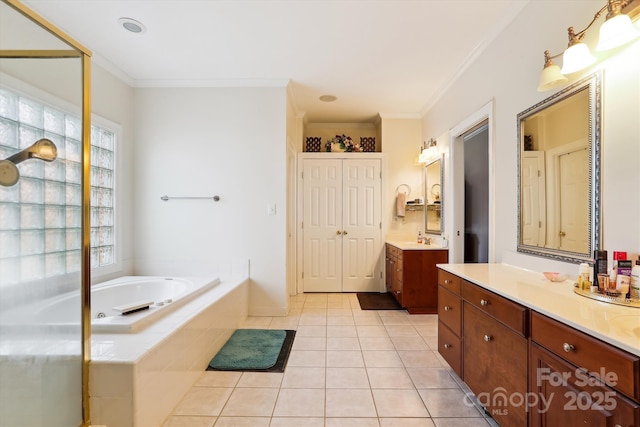 full bath with a garden tub, two vanities, a sink, tile patterned floors, and crown molding