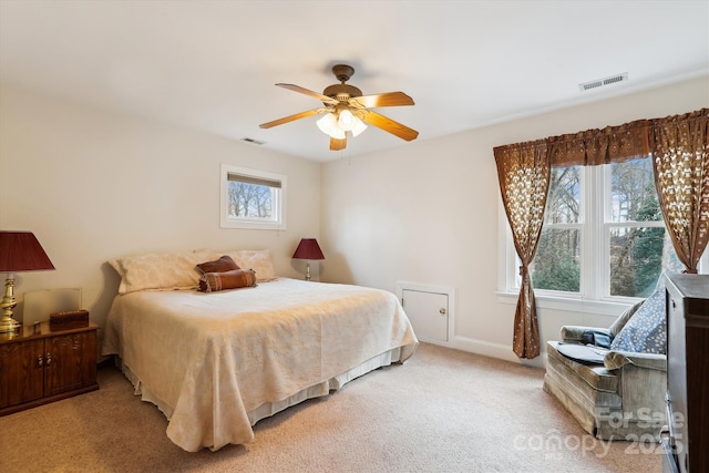 bedroom with baseboards, visible vents, a ceiling fan, and light colored carpet