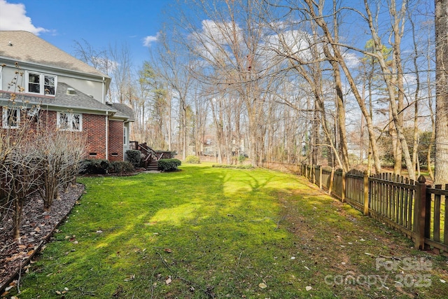 view of yard featuring a fenced backyard and stairway