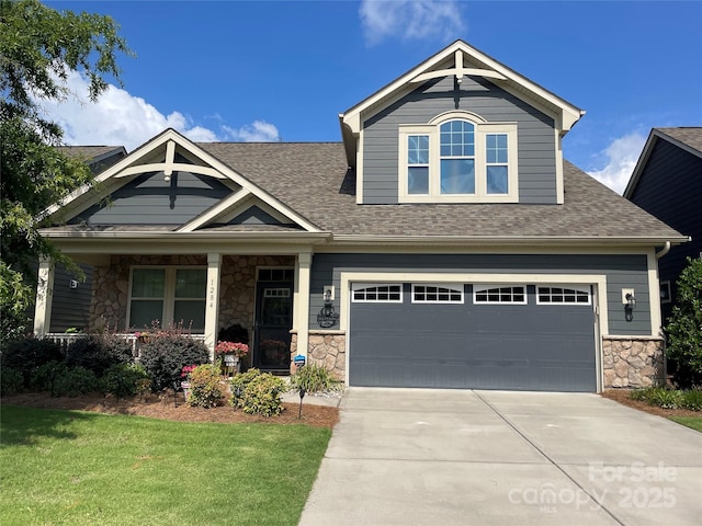 craftsman house with a garage and a front lawn