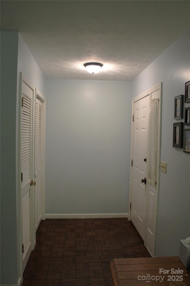 hall with a textured ceiling