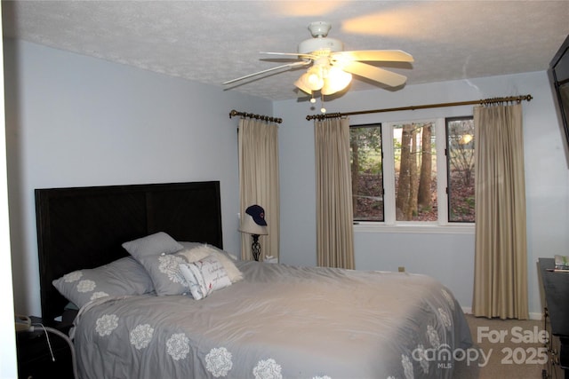 carpeted bedroom featuring a textured ceiling and ceiling fan