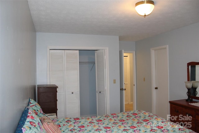 bedroom with a textured ceiling and a closet