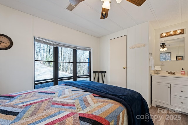 bedroom featuring hardwood / wood-style flooring, sink, and ceiling fan