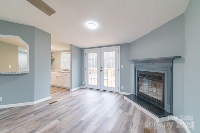 unfurnished living room featuring light hardwood / wood-style floors and french doors